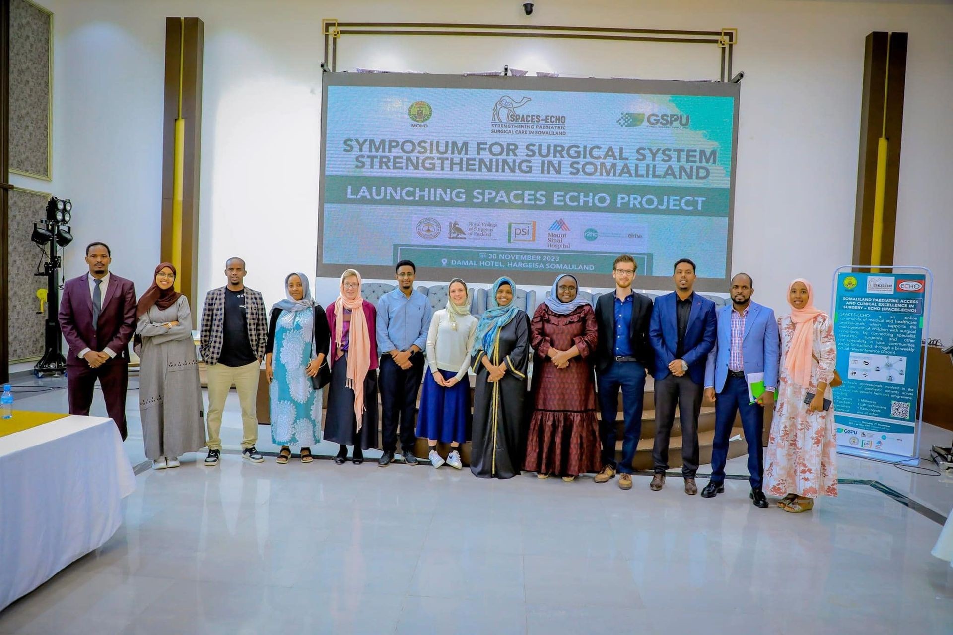 Group of people standing on a stage during the Symposium for Surgical System Strengthening in Somaliland.